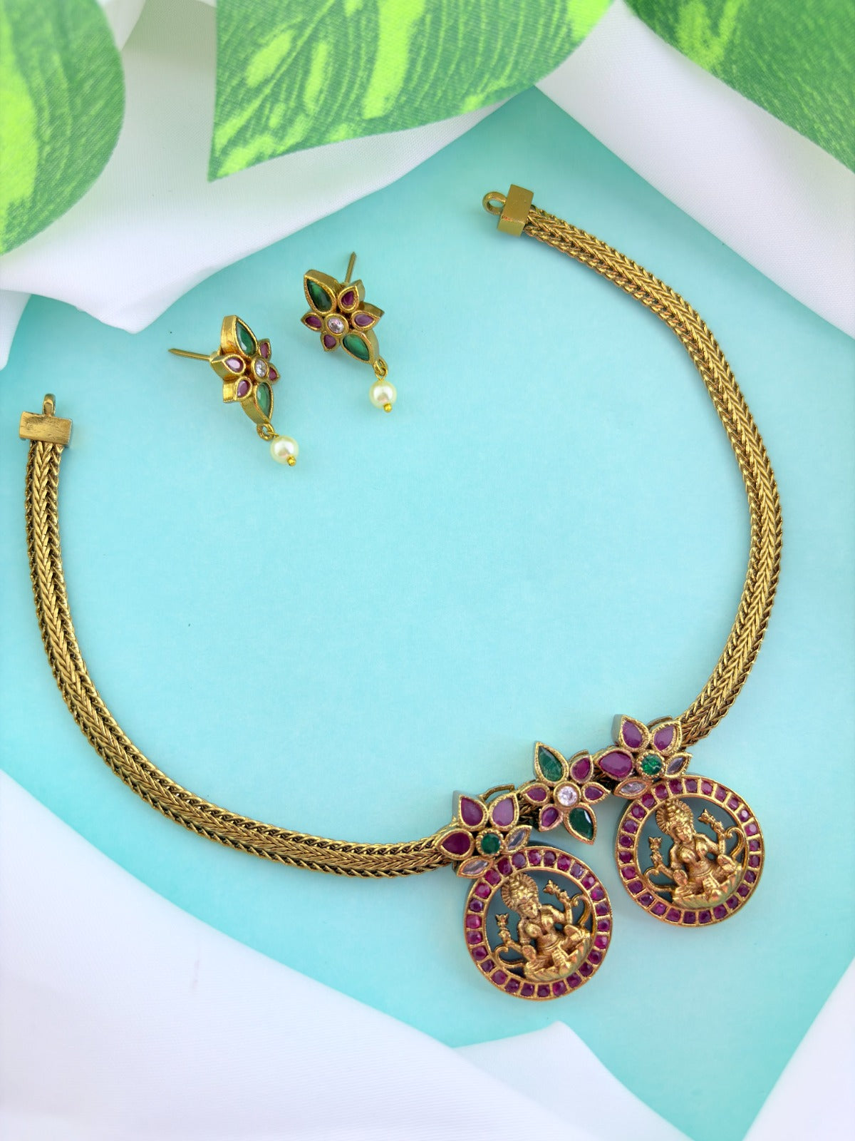 Premium antique finish necklace showcasing classic rich ruby and green stones with a lakshmi pendant and matching earrings
