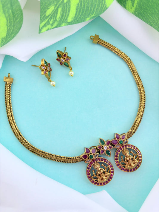 Premium antique finish necklace showcasing classic rich ruby and green stones with a lakshmi pendant and matching earrings