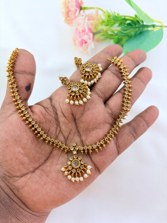 Elegant necklace and earrings crafted with classic kemp stones adorned with pearl drops