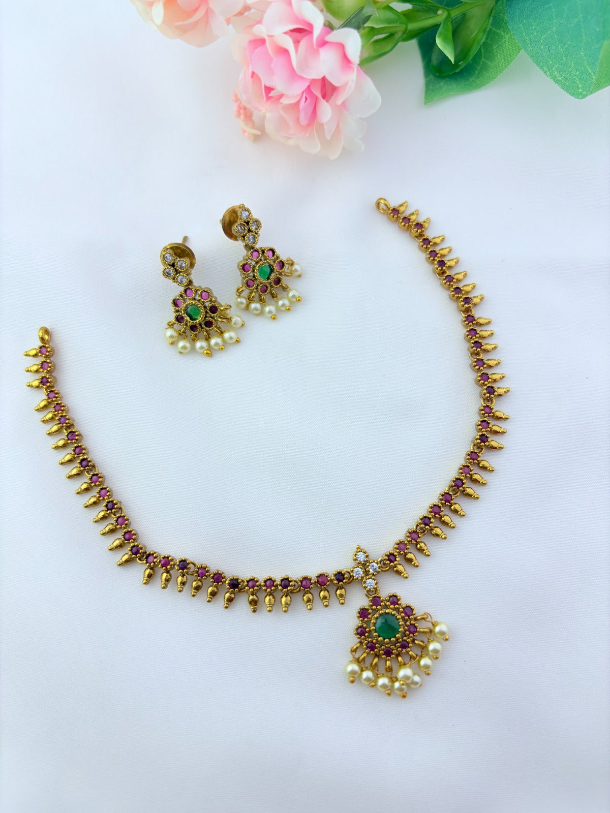 Elegant necklace and earrings crafted with classic kemp stones adorned with pearl drops