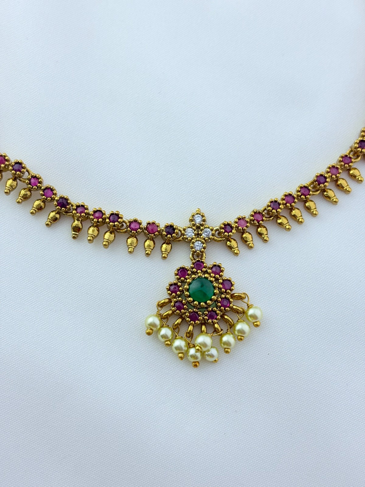 Elegant necklace and earrings crafted with classic kemp stones adorned with pearl drops