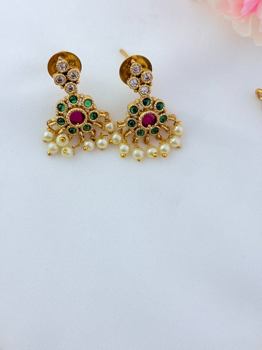 Elegant necklace and earrings crafted with classic kemp stones adorned with pearl drops