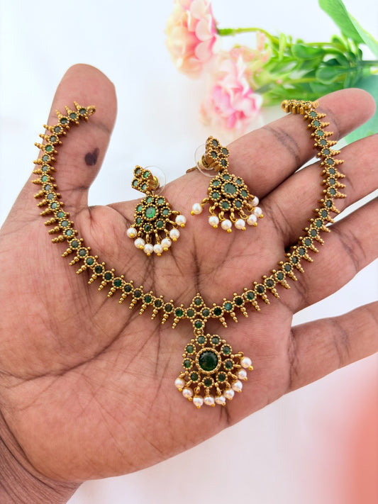 Elegant necklace and earrings crafted with classic kemp stones adorned with pearl drops