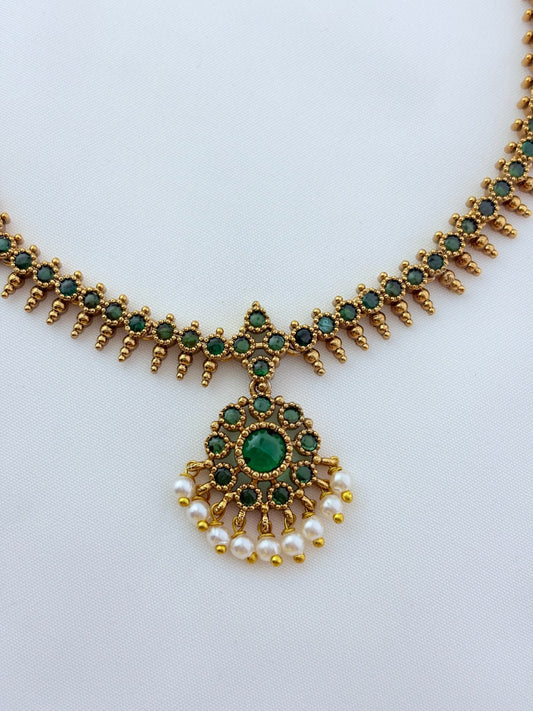 Elegant necklace and earrings crafted with classic kemp stones adorned with pearl drops