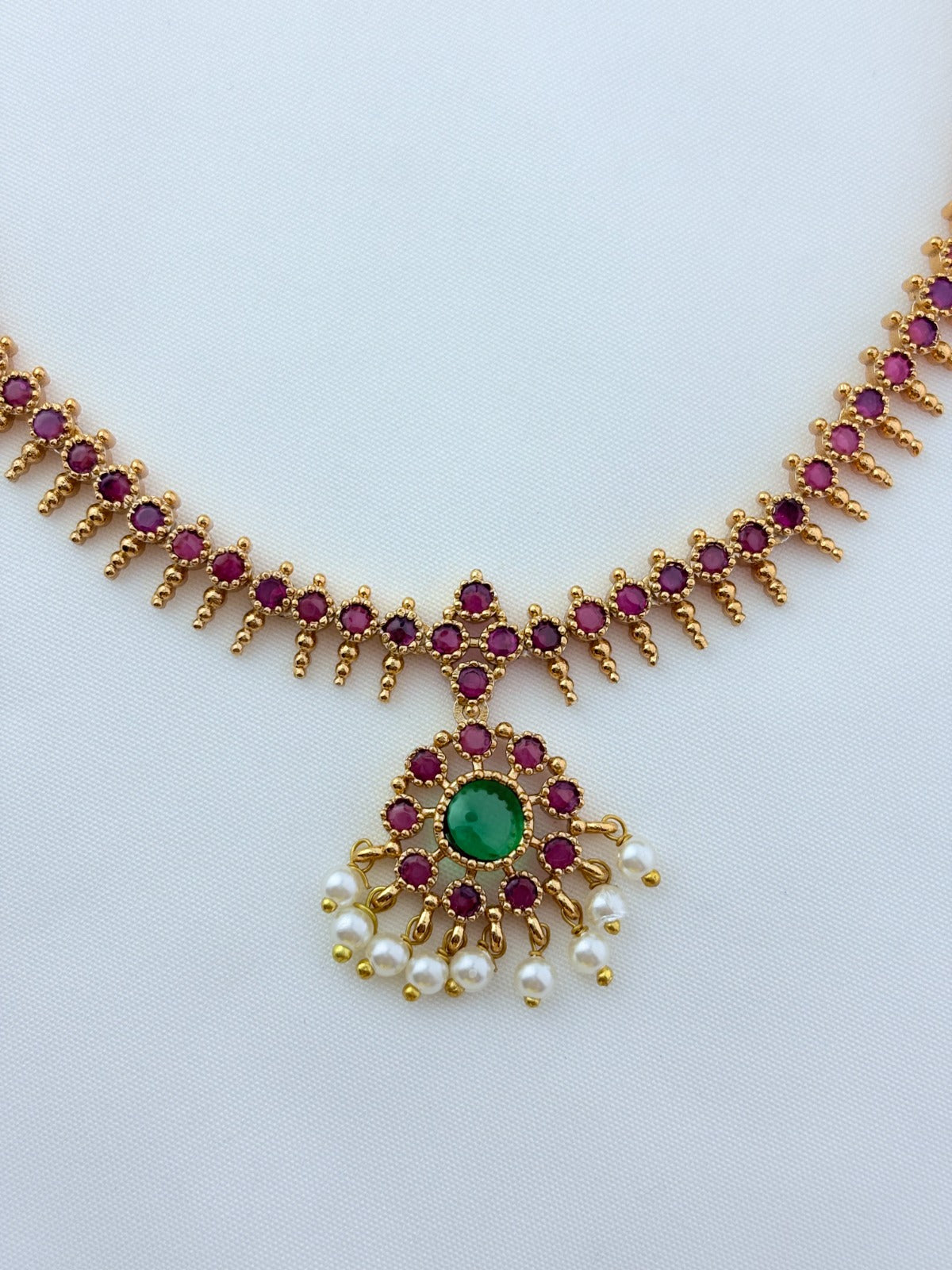 Elegant necklace and earrings crafted with classic kemp stones adorned with pearl drops