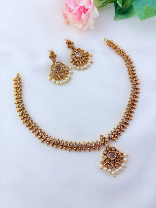 Elegant necklace and earrings crafted with classic kemp stones adorned with pearl drops