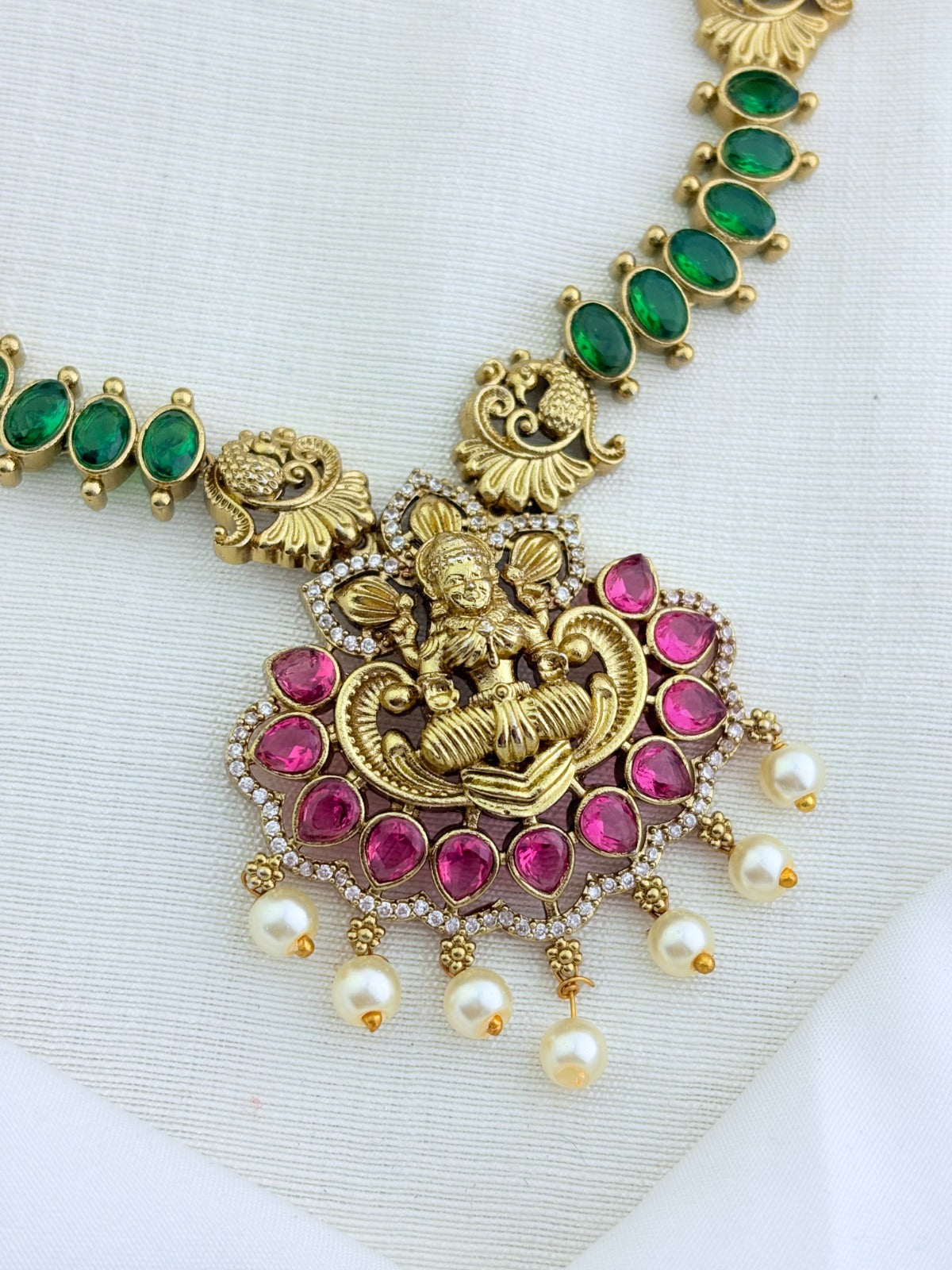 Premium matte finish Lakshmi pendant necklace beautifully crafted with classic ruby,green stones and pearl drops