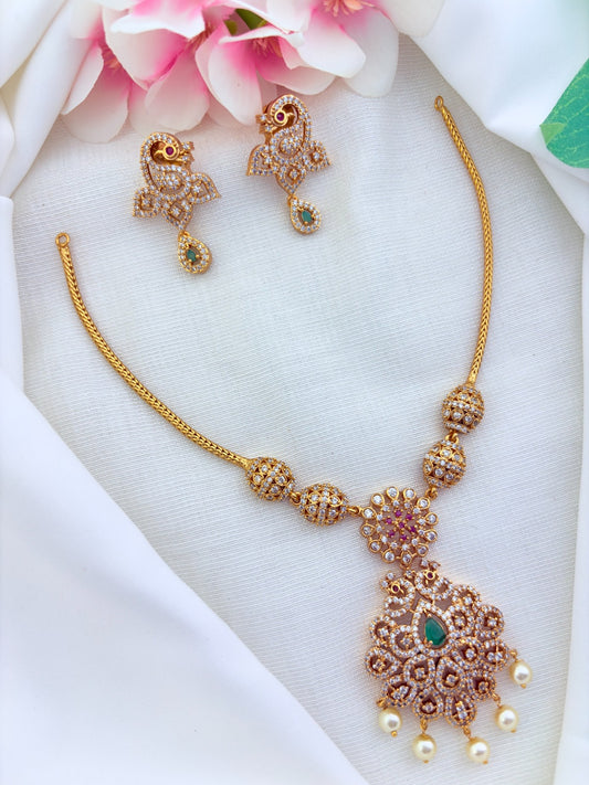 Elegant matte finish peacock motif necklace adorned with AD stones and pearl drops