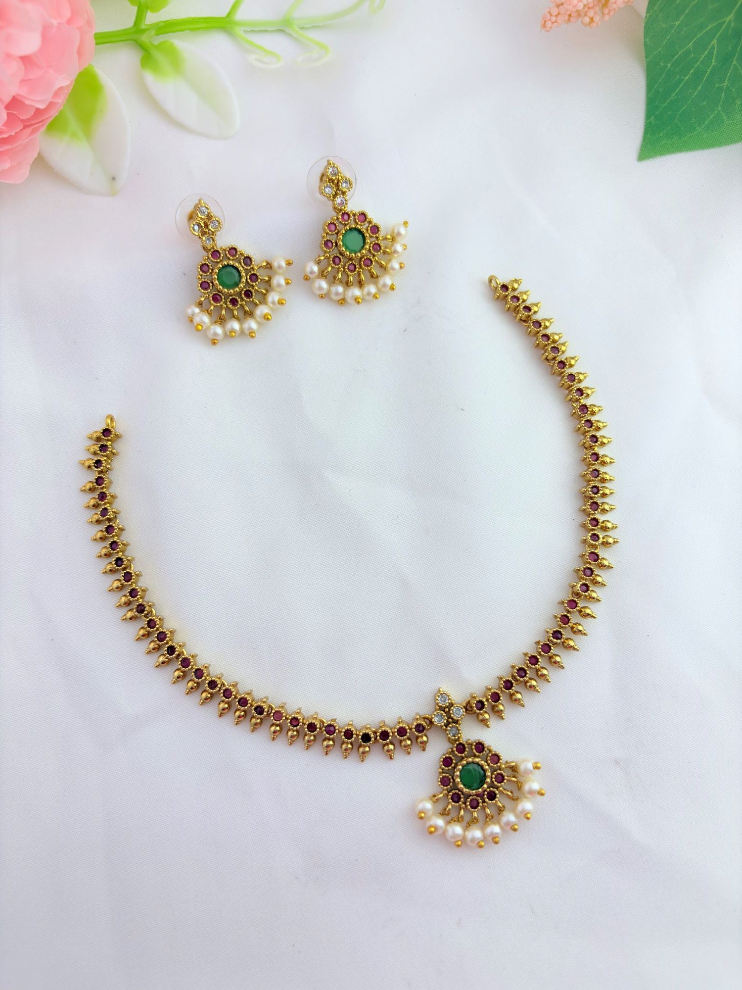 Premium matte finish neckset adorned with ruby and green stones for a rich traditional look