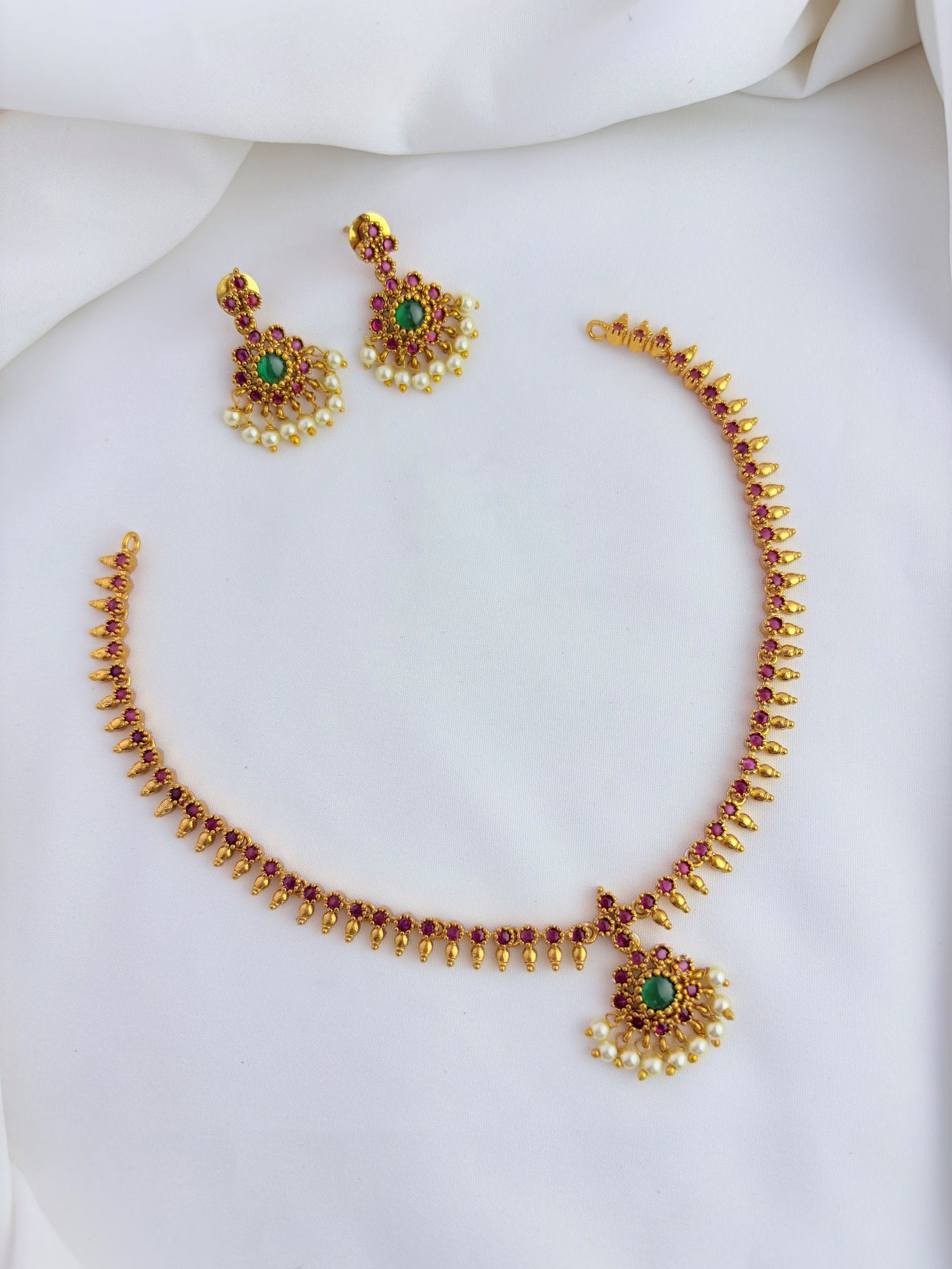 Elegant necklace and earrings crafted with classic kemp stones adorned with pearl drops