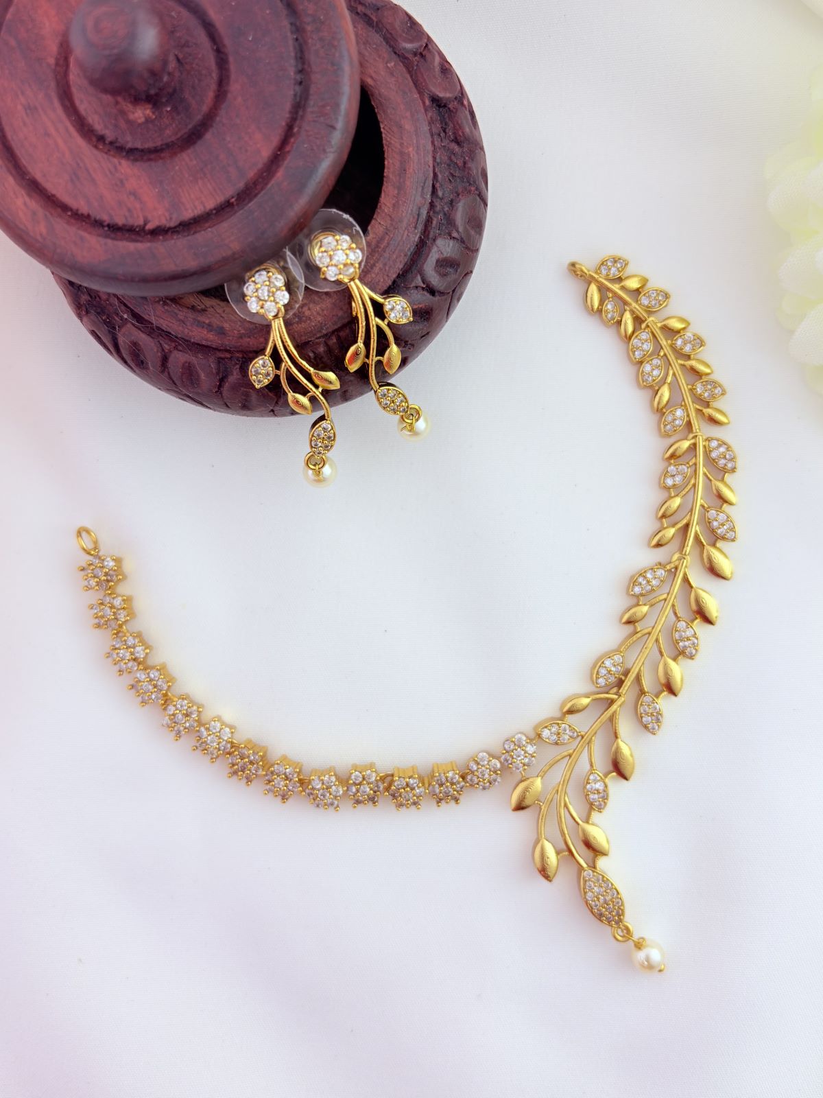 Classic floral and leaf pattern beautifully crafted with AD stones and pearl drops