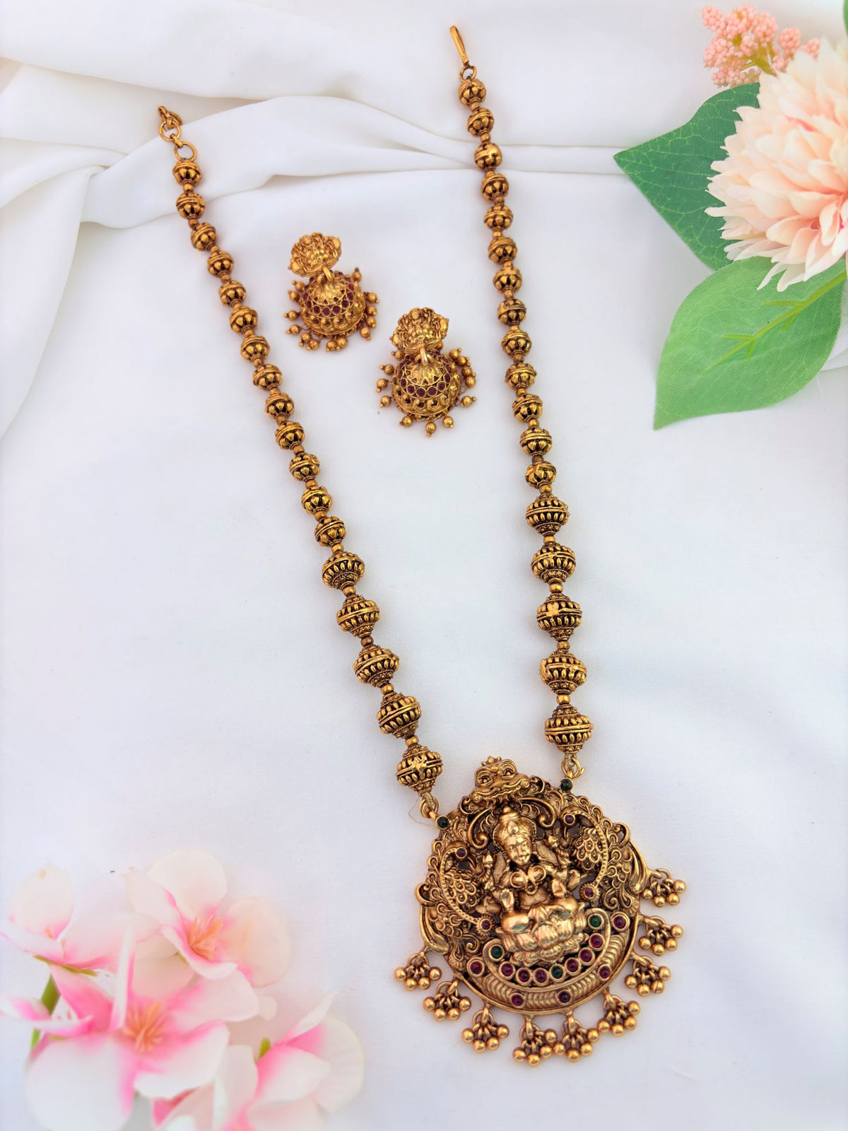 Traditional Lakshmi pendant beautifully embellished with ruby and green stones