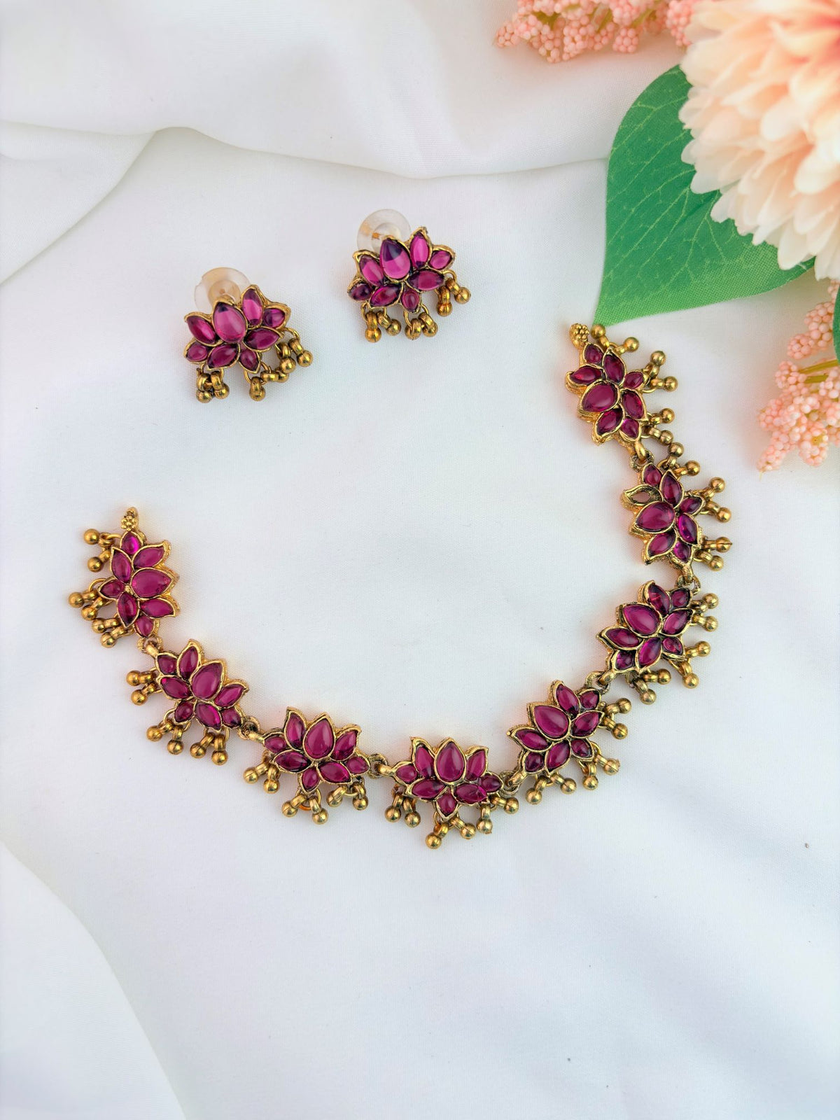 Matte finish lotus patern neckset adorned with ruby stones and golden beads