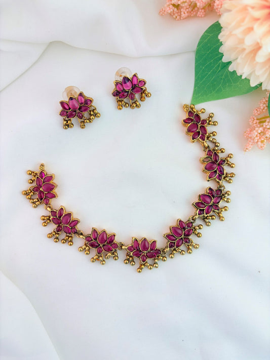 Matte finish lotus patern neckset adorned with ruby stones and golden beads