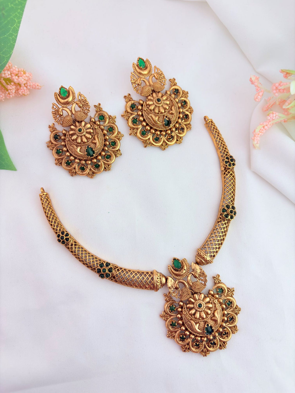 Matte finish neckset with matching earrings adorned with green stones