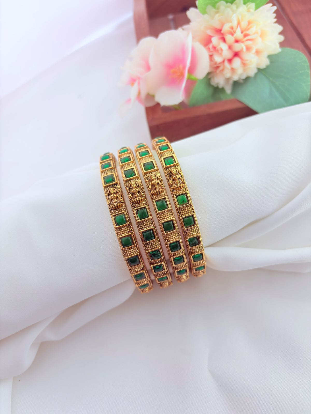 Beautifully designed lakshmi bangles in matte finish adorned with green stones