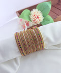 Elegant matte finish bangles embellished with vibrant ruby and green stones for a timeless traditional look