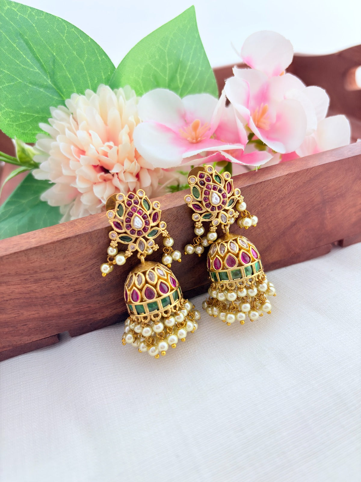 Traditional lotus motif jhumka in premium matte finish, adorned with stones and pearls