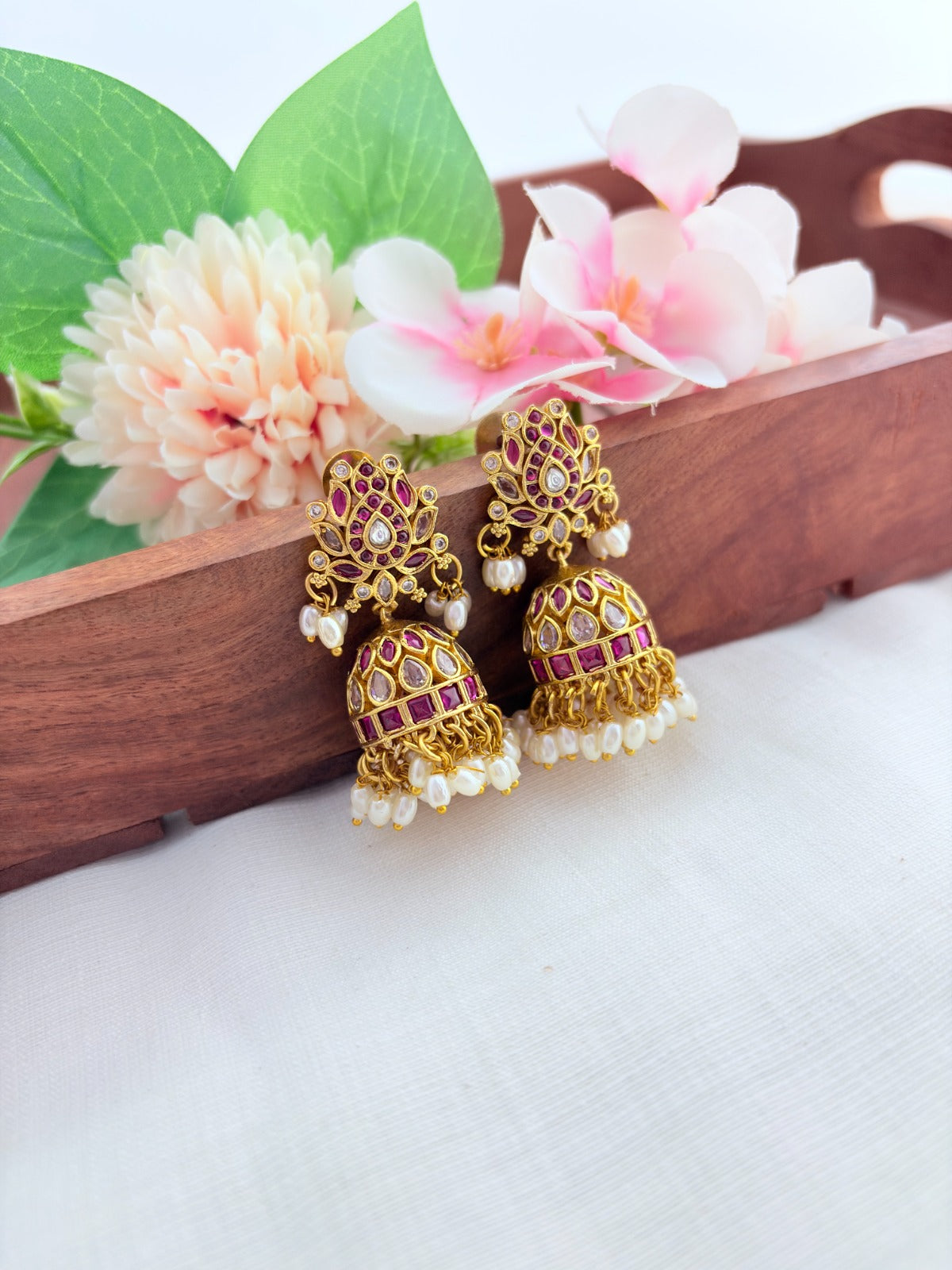 Traditional lotus motif jhumka in premium matte finish, adorned with stones and pearls