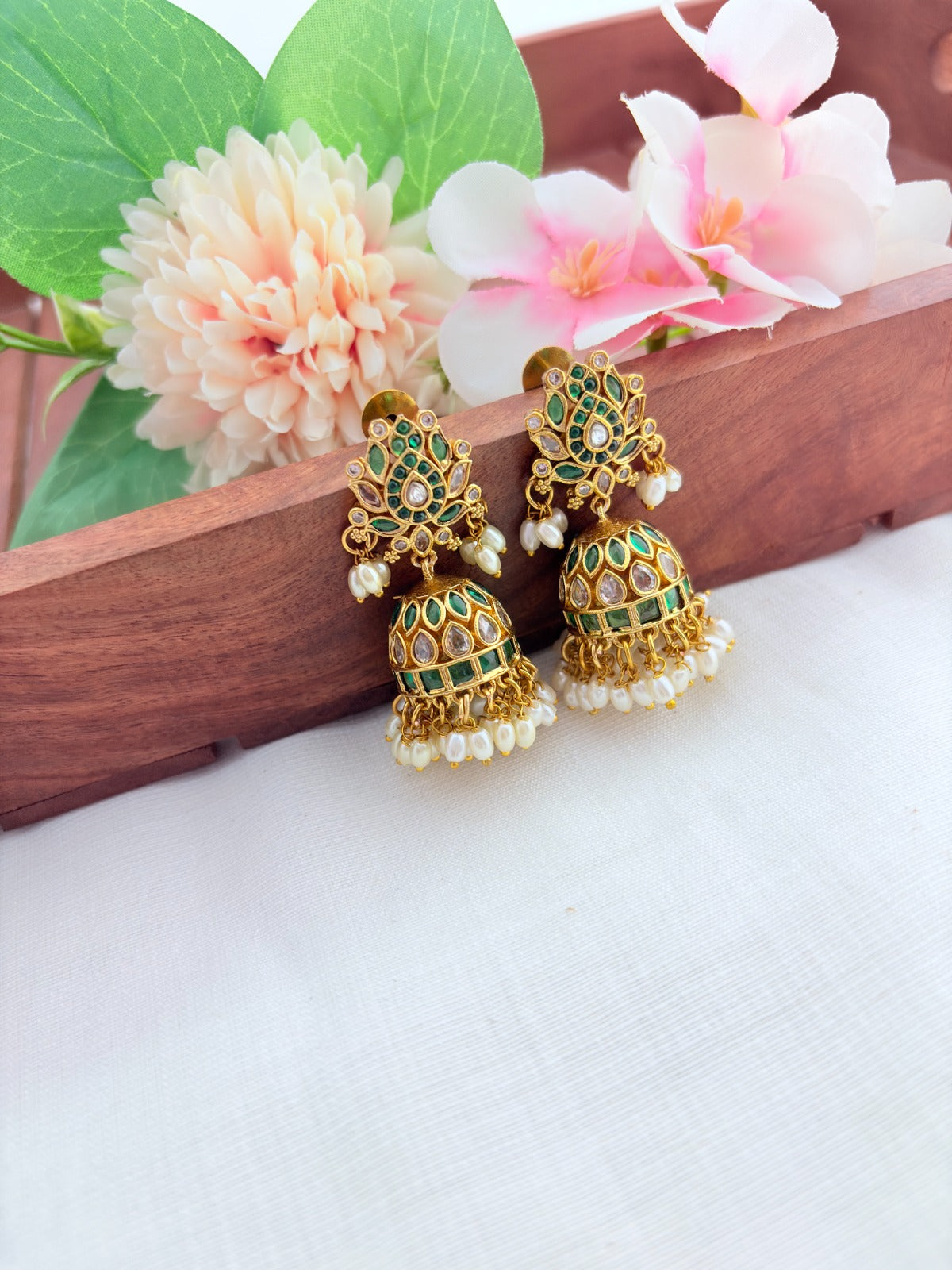 Traditional lotus motif jhumka in premium matte finish, adorned with stones and pearls