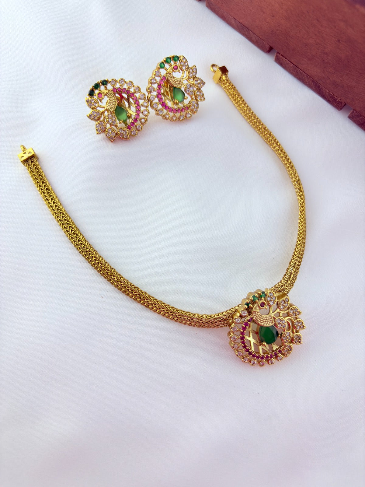 Elegant peacock motif pendant choker paired with matching earrings