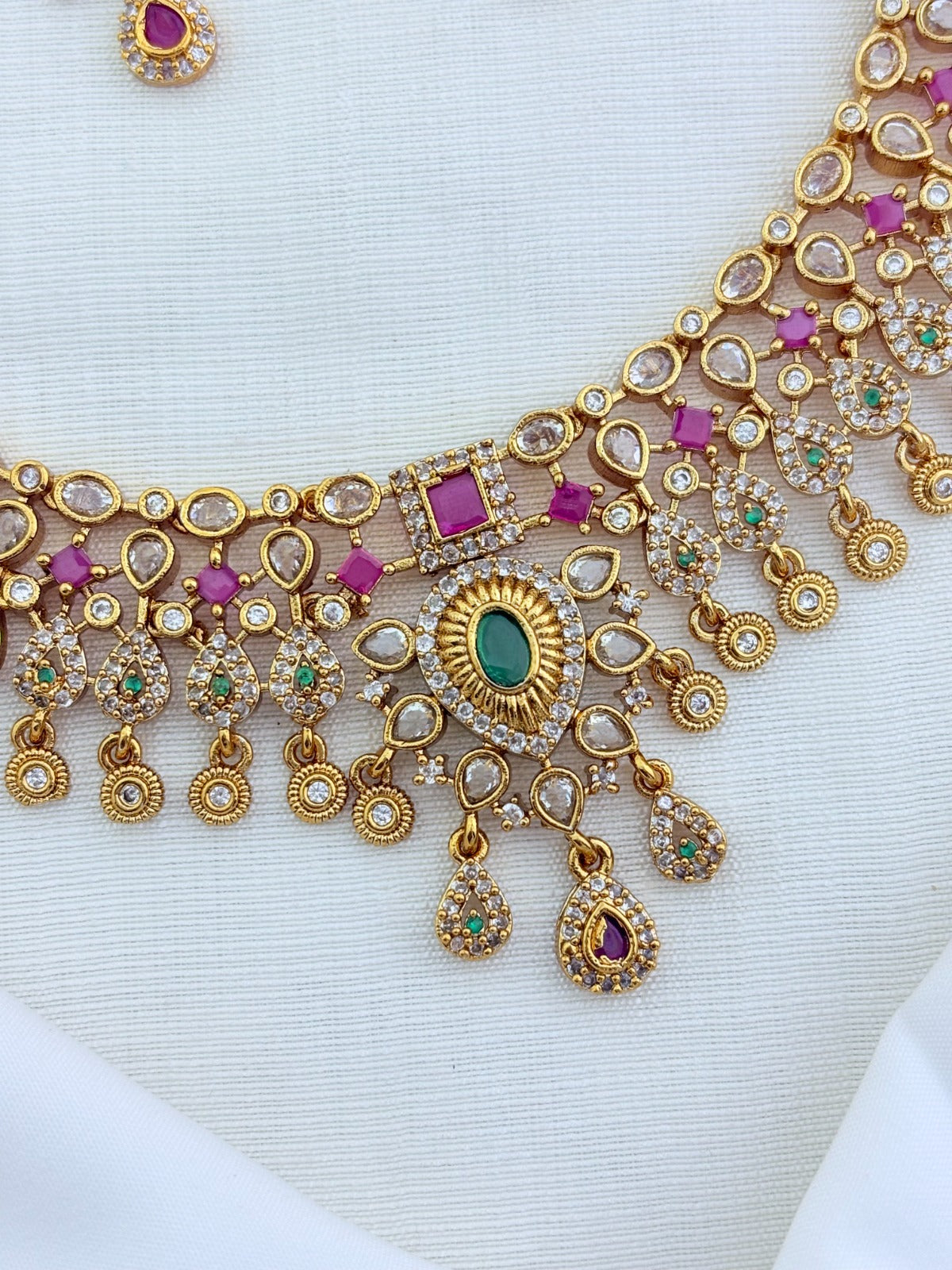 Beautifully crafted with ruby, white and green stone accents- Premium matte finish bridal necklace with matching earrings