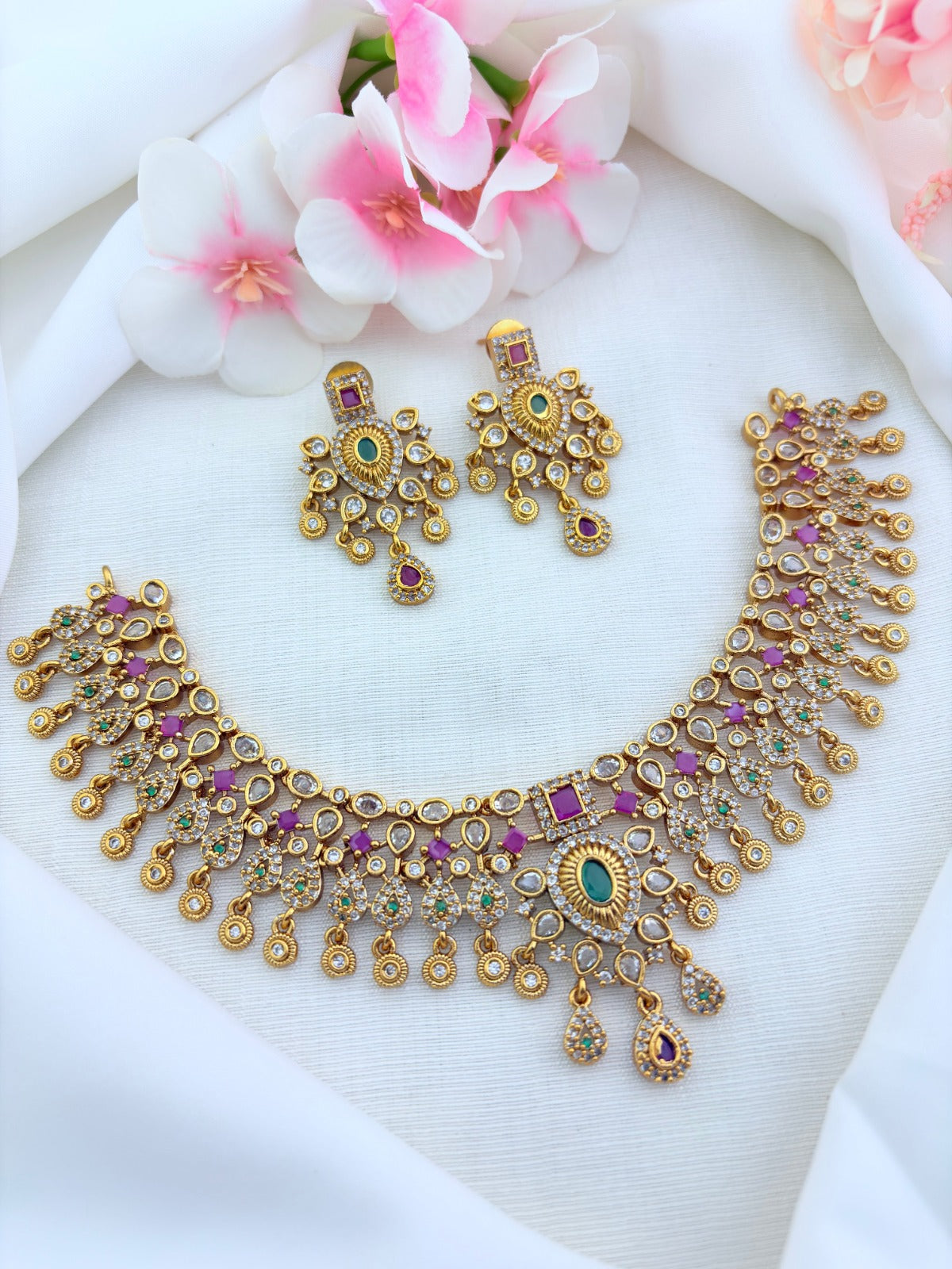 Beautifully crafted with ruby, white and green stone accents- Premium matte finish bridal necklace with matching earrings