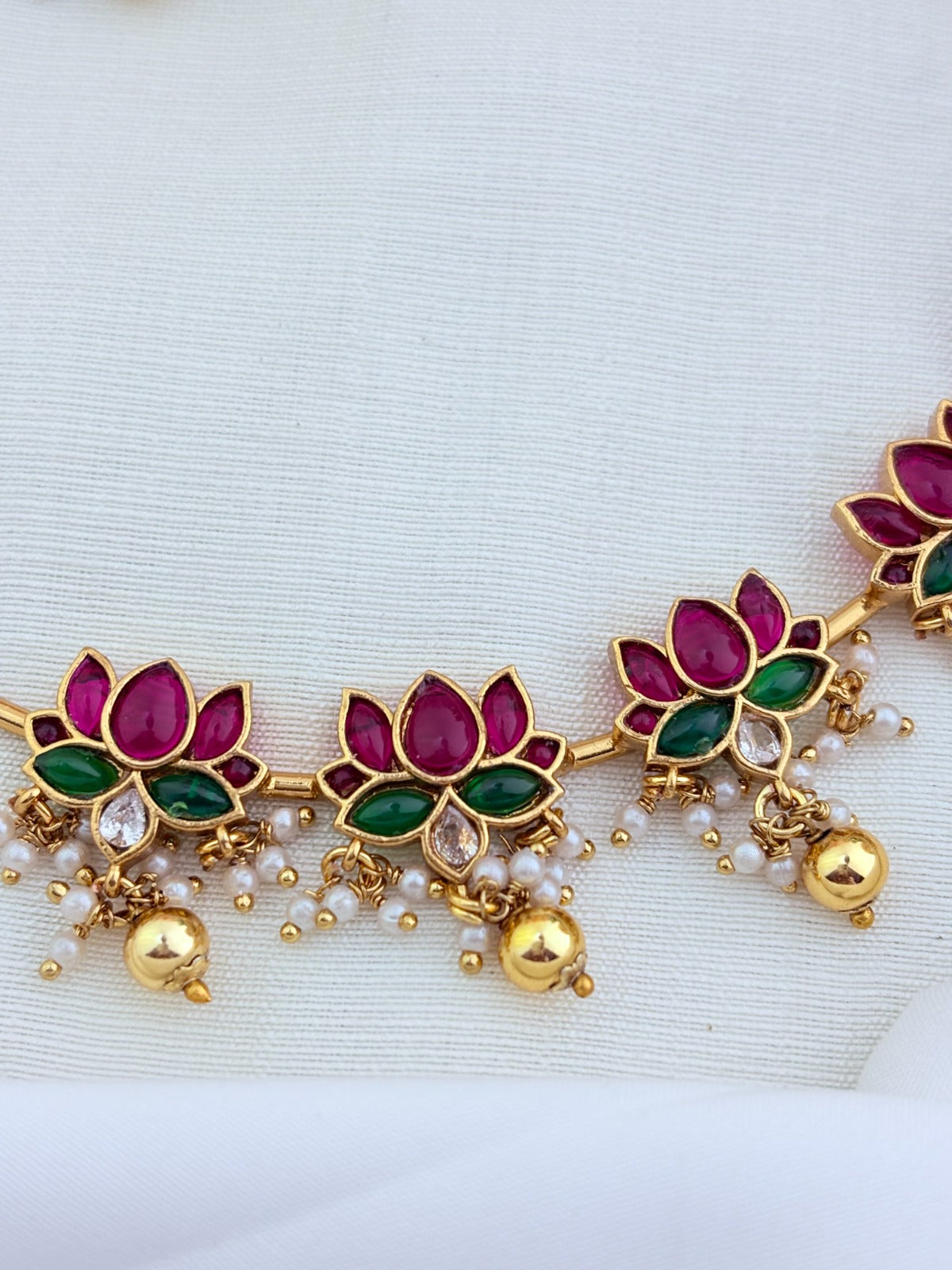 Traditionally crafted louts-motif hasli neckset in premium matte finish, highlighted with golden and pearl drops