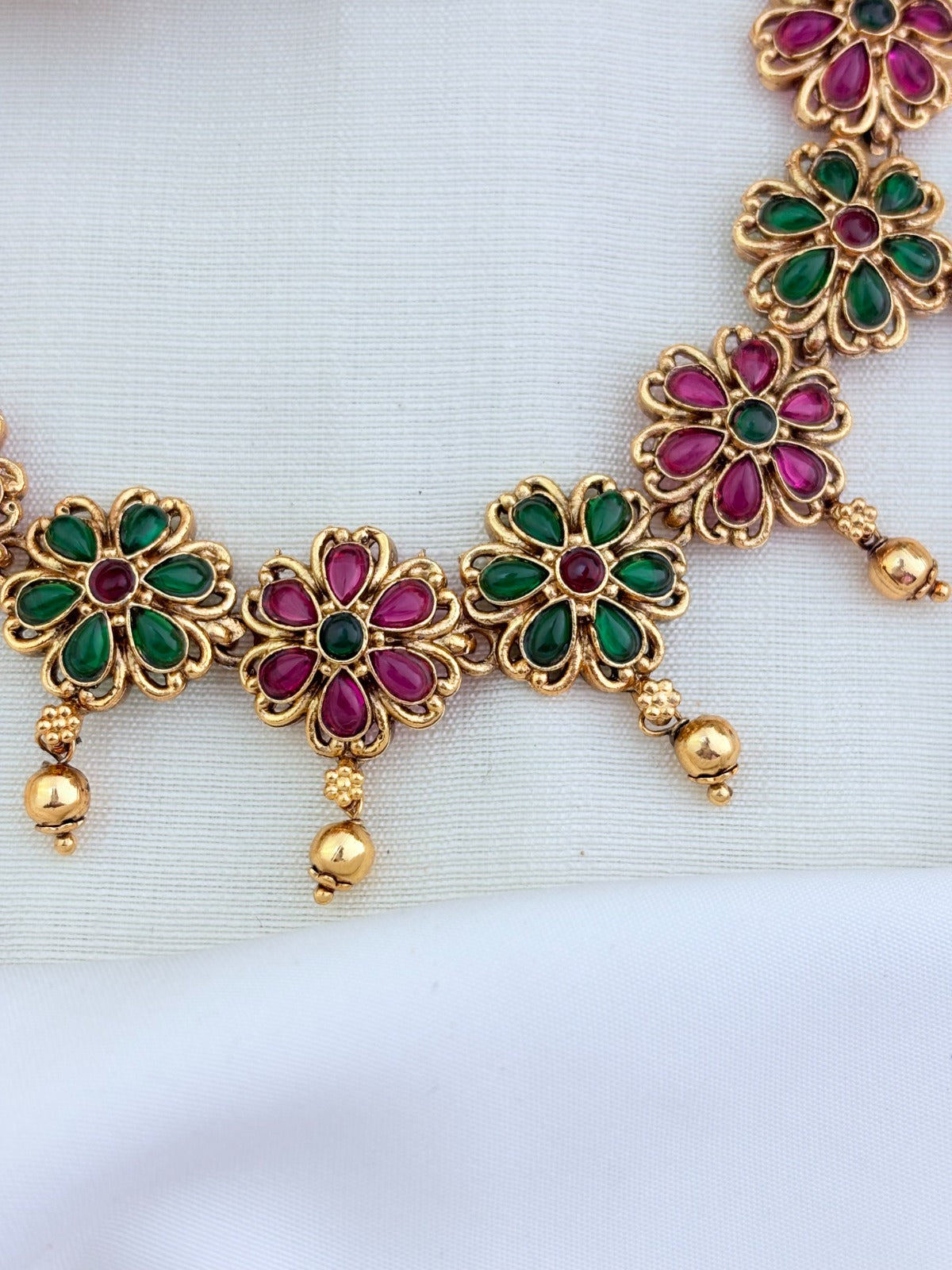 Matte finish floral pattern neckset and jhumka adorned with classic stones and golden beads