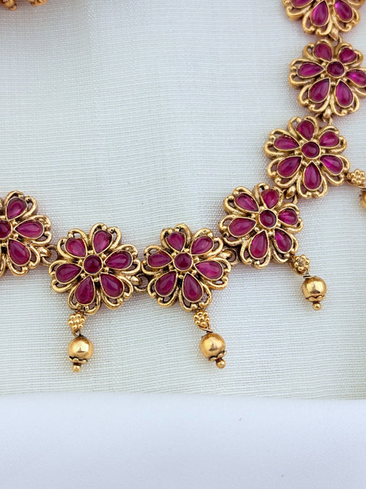 Matte finish floral pattern neckset and jhumka adorned with classic stones and golden beads