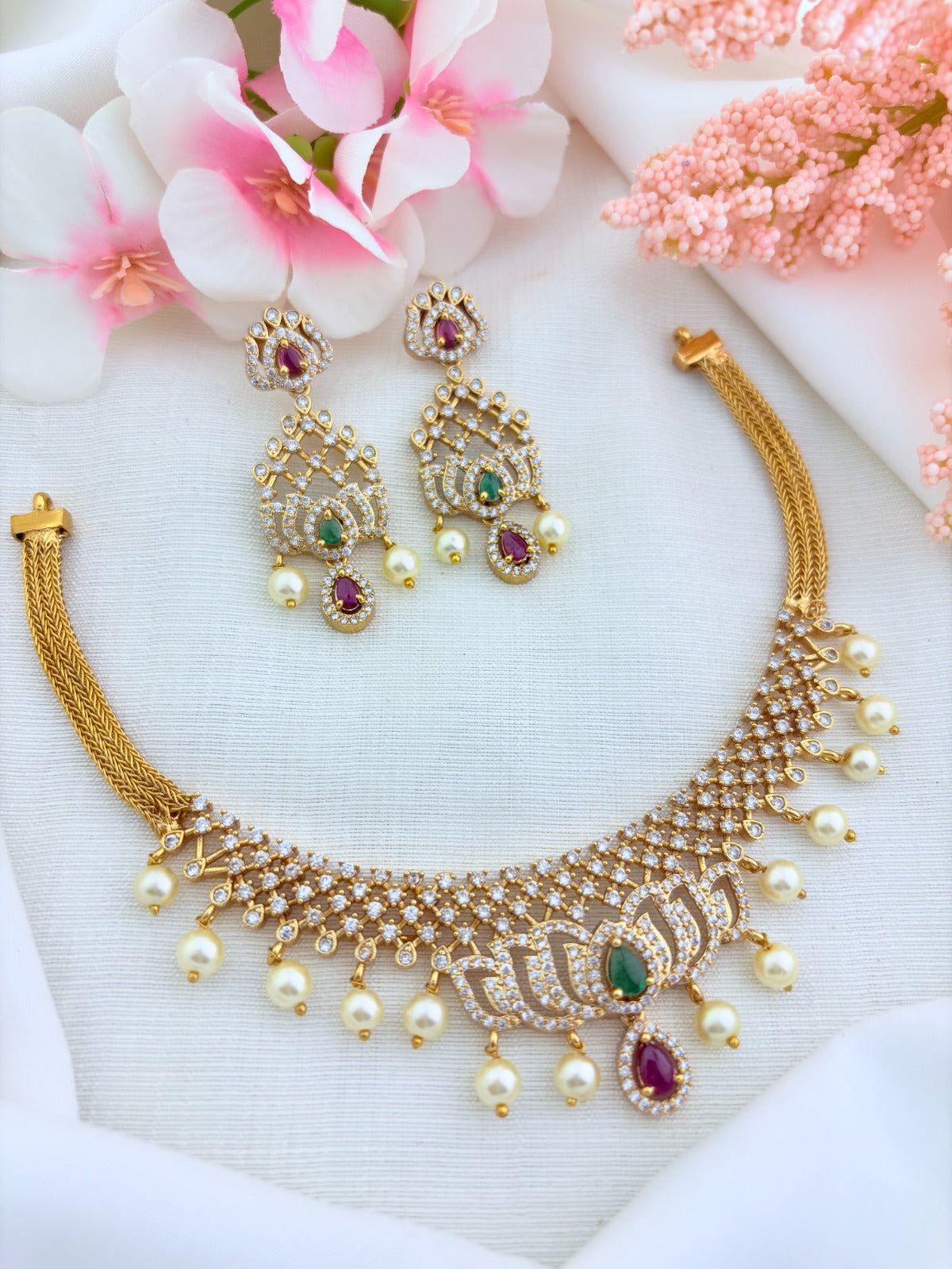 Classic lotus motif necklace adorned with AD stones and elegant pearl drops with matching earrings