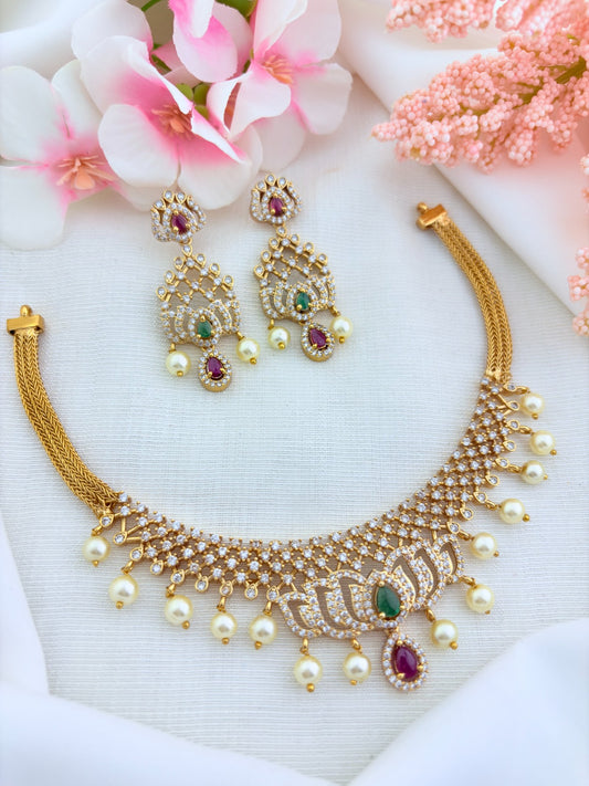 Classic lotus motif necklace adorned with AD stones and elegant pearl drops with matching earrings