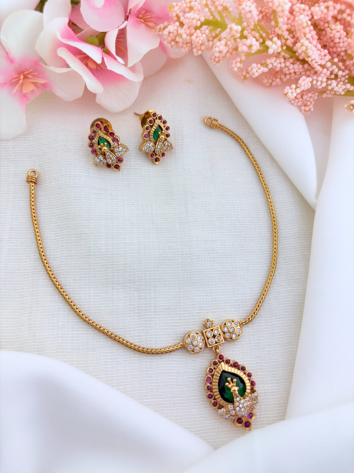 Beautifully crafted peacock pendant featuring AD stones in premium matte finish with matching earrings