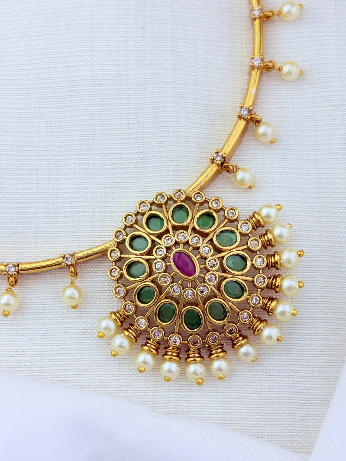 Premium matte finish necklace and earrings adorned with classic stones and pearl drops