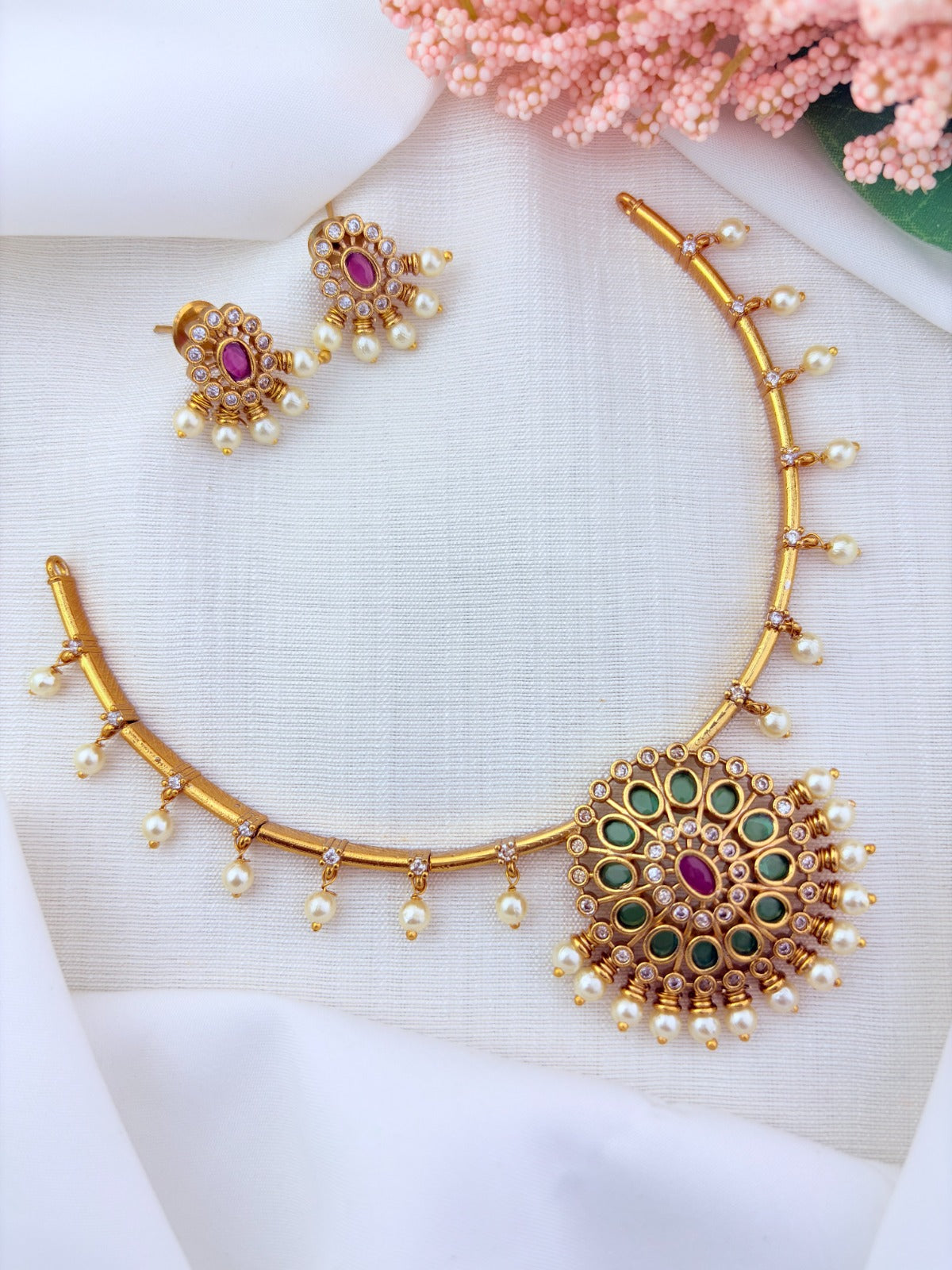 Premium matte finish necklace and earrings adorned with classic stones and pearl drops