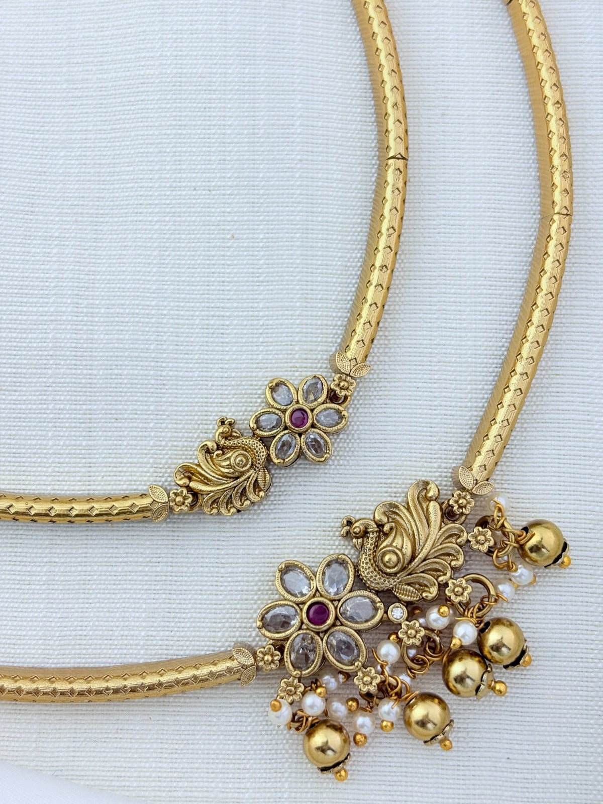 Classic layered necklace showcasing peacock and floral artistry, enriched with stones and highlighted pearl & gold drops