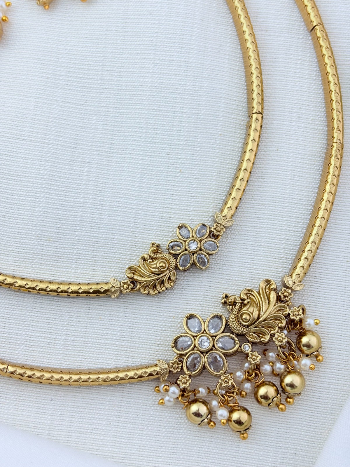 Classic layered necklace showcasing peacock and floral artistry, enriched with stones and highlighted pearl & gold drops